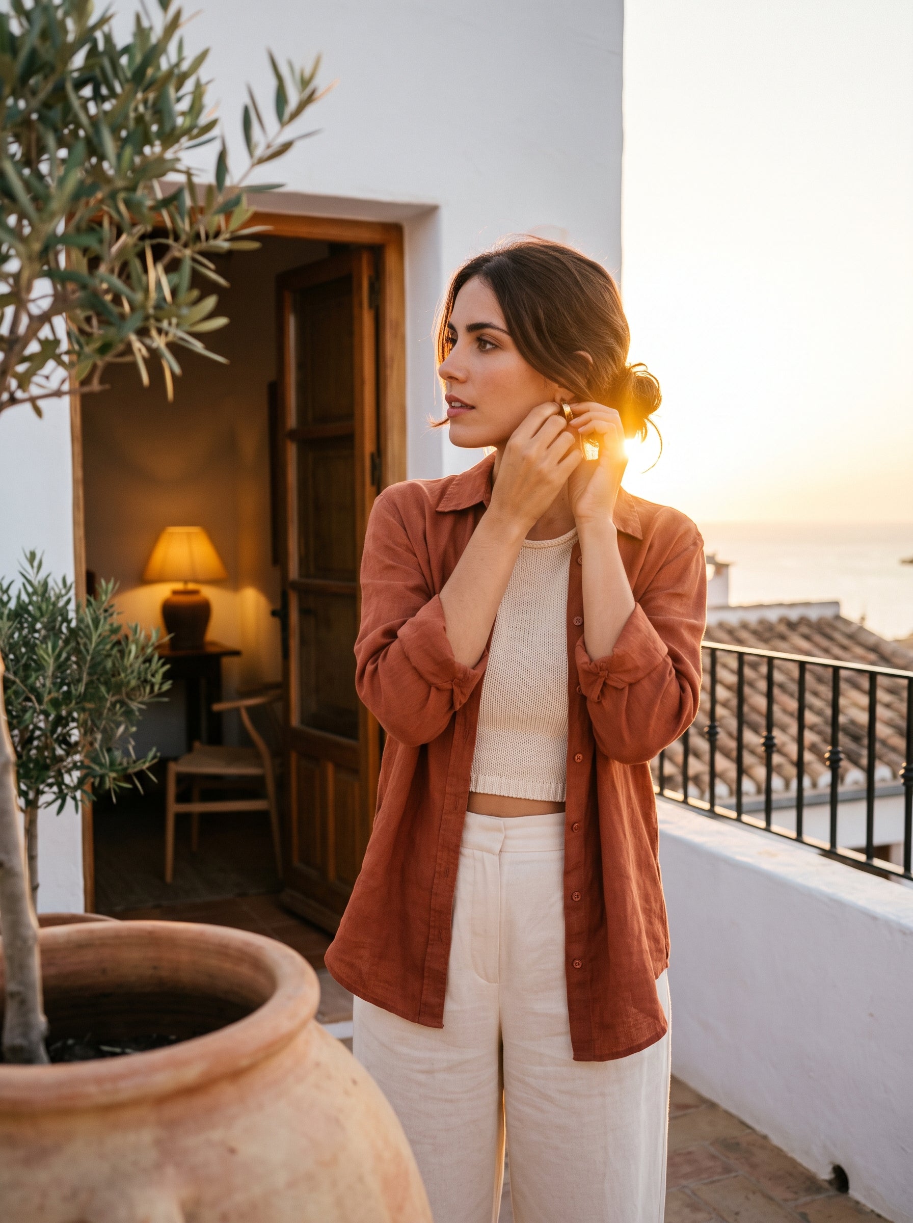 Camisa de lino en terracota y pantalon de lino crema en una terraza encalada al atardecer
